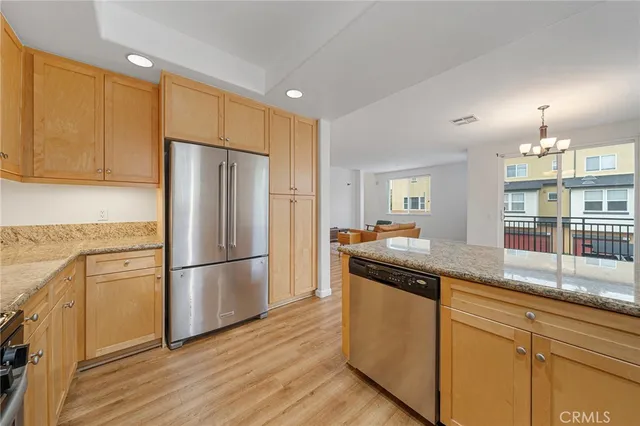 a kitchen with granite countertop a refrigerator and a sink