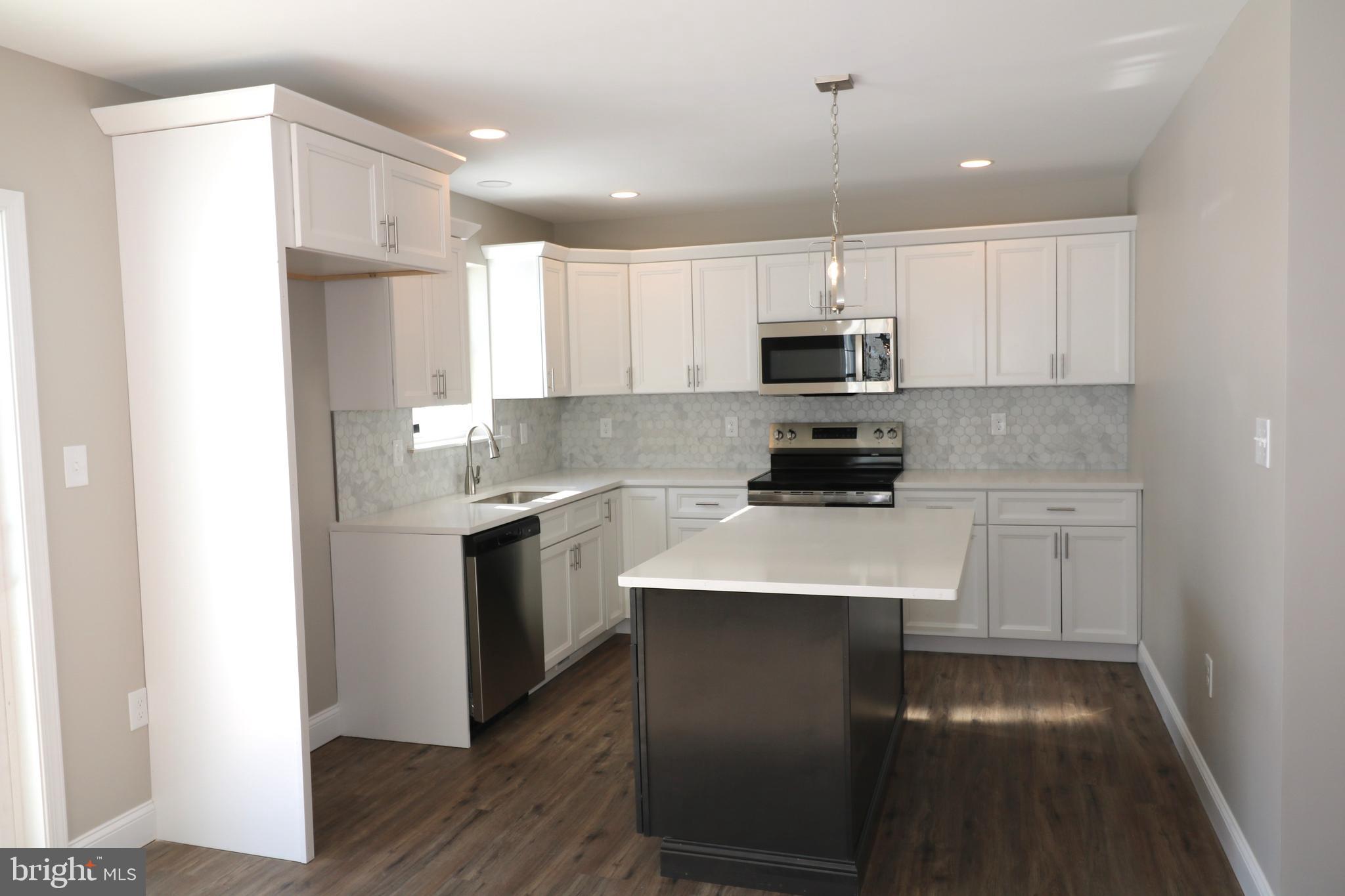 38 Rosalie's Way Temple, PA 19560 - Photo 4 of 15 a kitchen with kitchen island white cabinets and stainless steel appliances