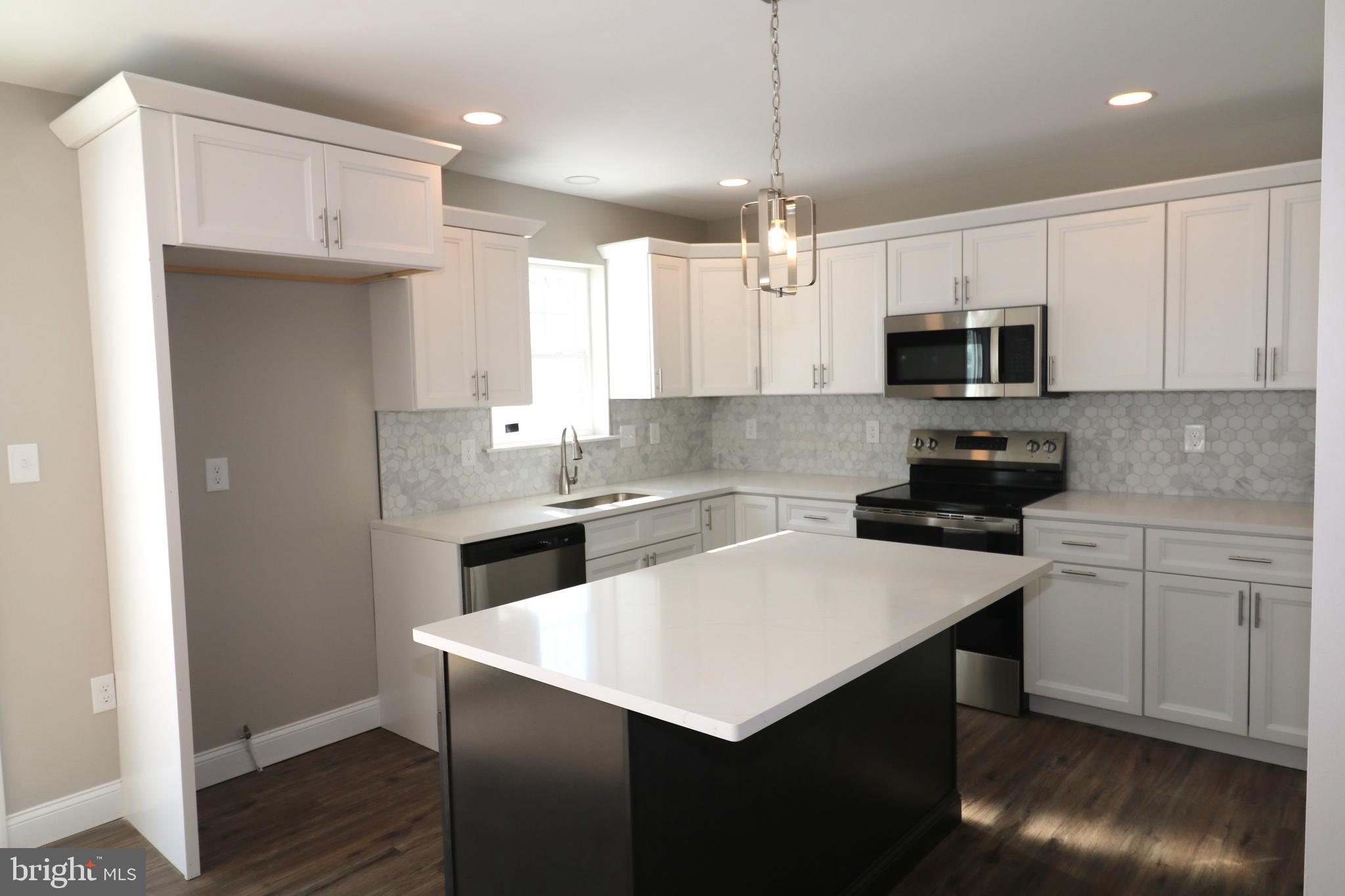 38 Rosalie's Way Temple, PA 19560 - Photo 5 of 15 a kitchen with a sink a stove a refrigerator and white cabinets