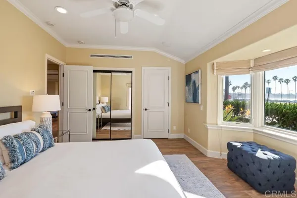 a living room with a balcony a bed furniture and a large window