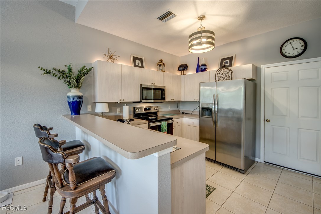 3181 Matecumbe Key Road, Unit 11 Punta Gorda, FL 33955 - Photo 25 of 50 a kitchen with a refrigerator a stove and a dining table