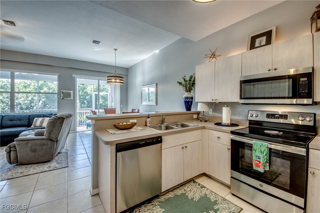 3181 Matecumbe Key Road, Unit 11 Punta Gorda, FL 33955 - Photo 26 of 50 a kitchen with a sink stove and microwave