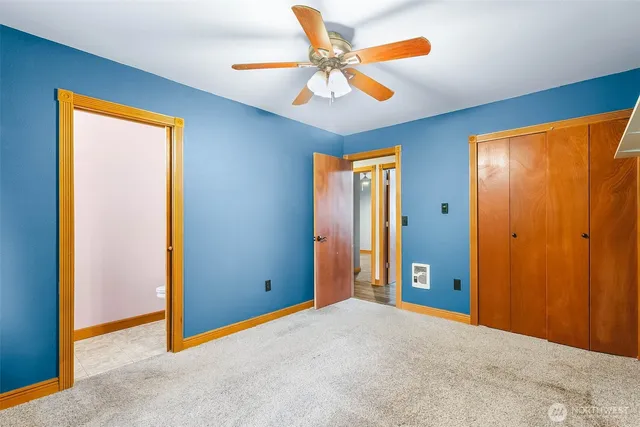 an empty room with closet and a chandelier fan