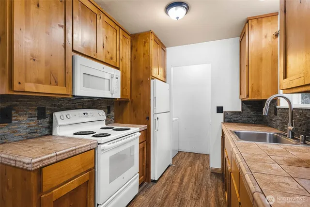 a kitchen with granite countertop a sink stove and cabinets