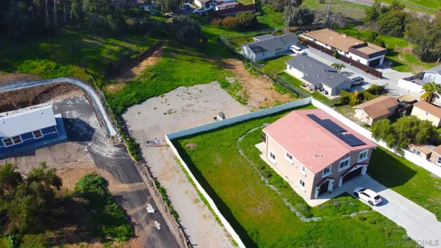 an aerial view of a tennis ground and a cars park side of the road