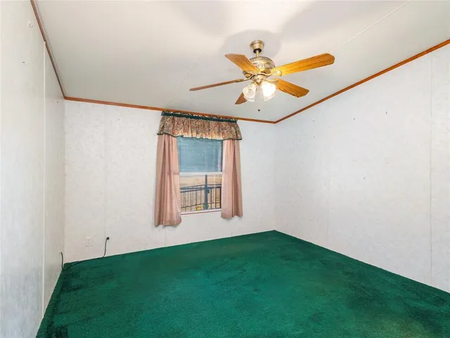 a view of a room with a ceiling fan and a window