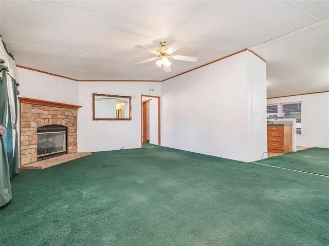 a view of empty room with fireplace and fan