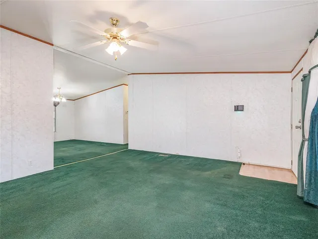 a view of a big room with an empty space and a ceiling fan
