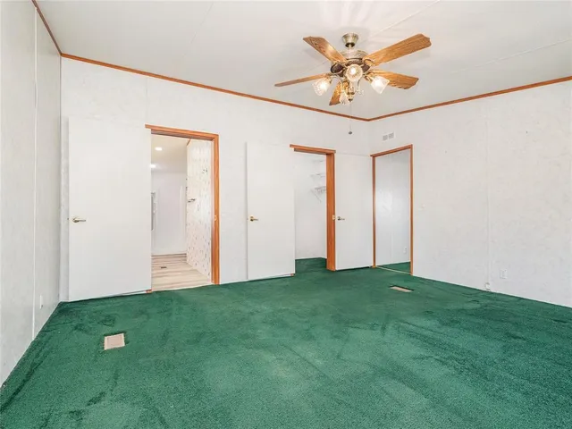 a view of a big room with a ceiling fan and closet area