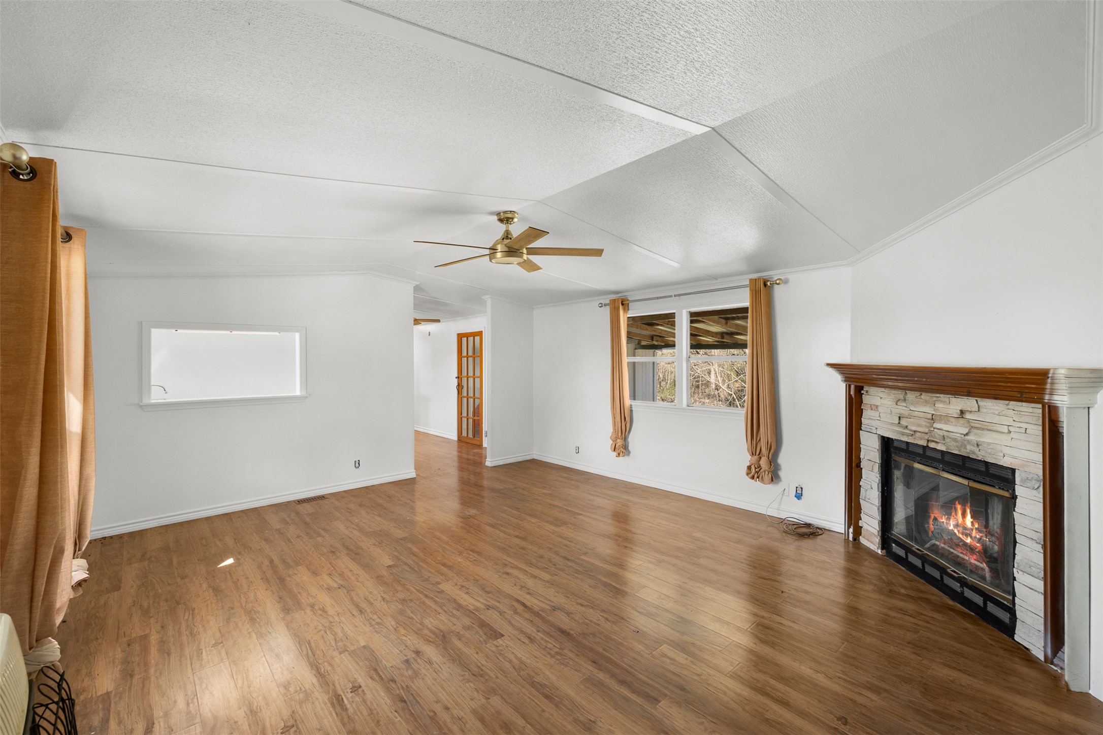 1919 County Road 344 Loop Milano, TX 76556 - Photo 4 of 21 an empty room with wooden floor fireplace and windows
