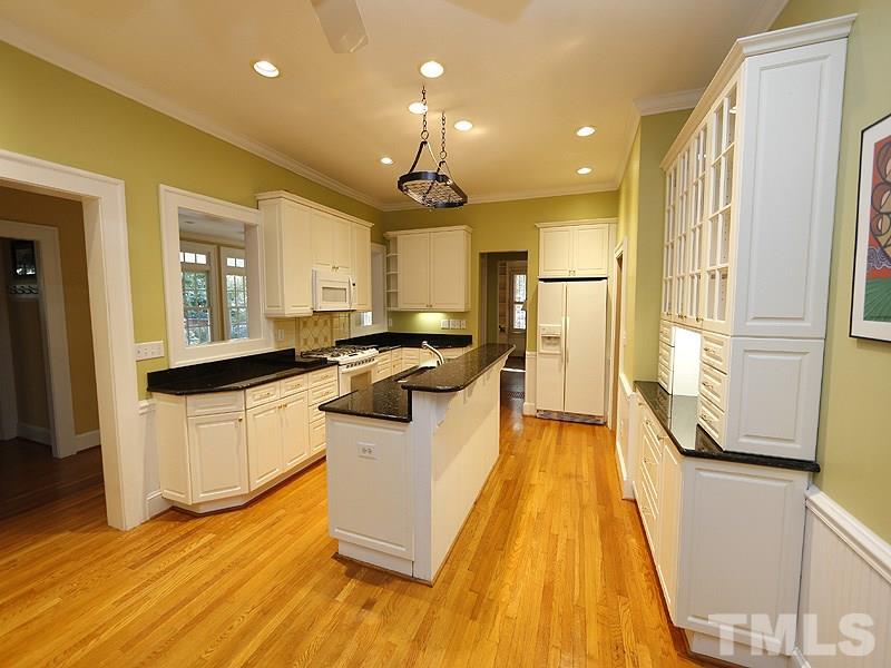 1804 St Marys Street Raleigh, NC 27608 - Photo 9 of 25 a kitchen with counter top space a sink a refrigerator and white cabinets