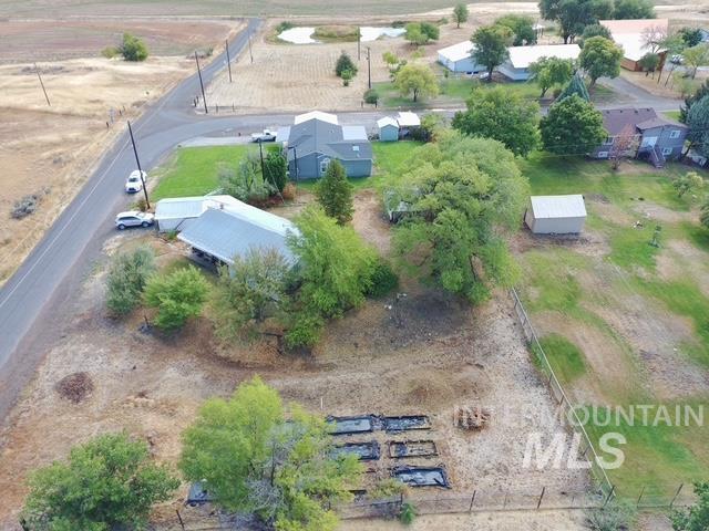 555 Cemetery Road Cambridge, ID 83610 - Photo 36 of 41 Property exterior with metal roofing, mature trees, a detached storage building, and fenced garden beds