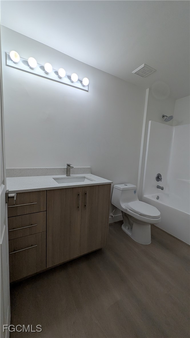 5114 27th Street Southwest Lehigh Acres, FL 33973 - Photo 16 of 26 a bathroom with a sink a toilet and vanity