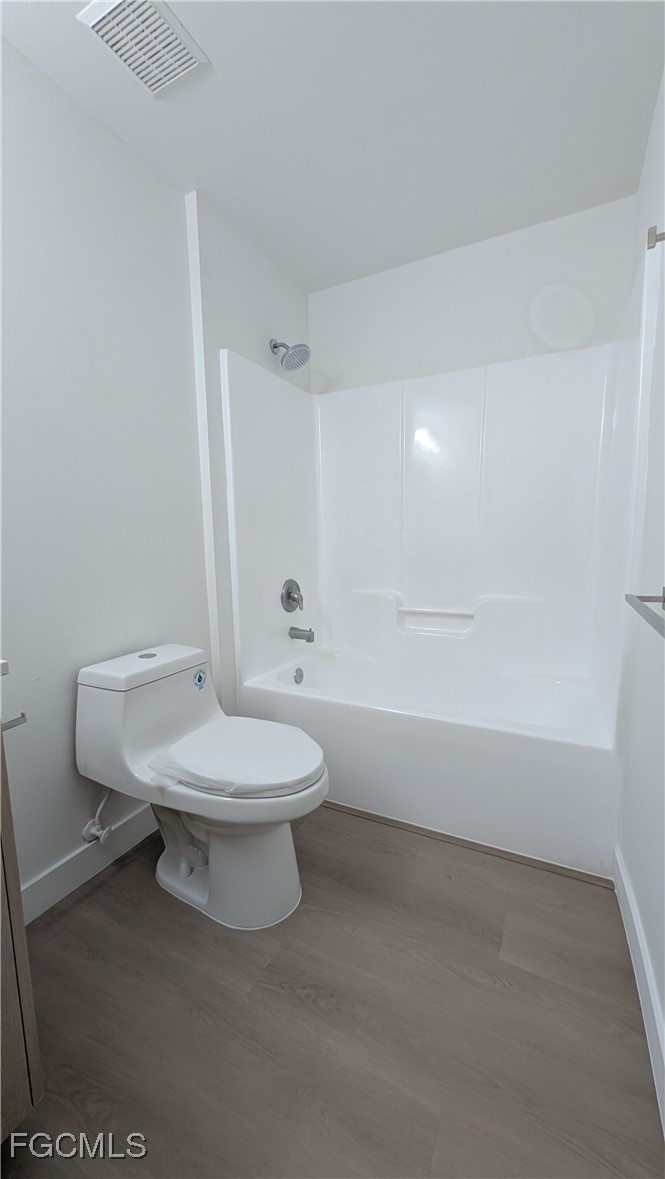 5114 27th Street Southwest Lehigh Acres, FL 33973 - Photo 17 of 26 a white toilet sitting next to a bathroom sink