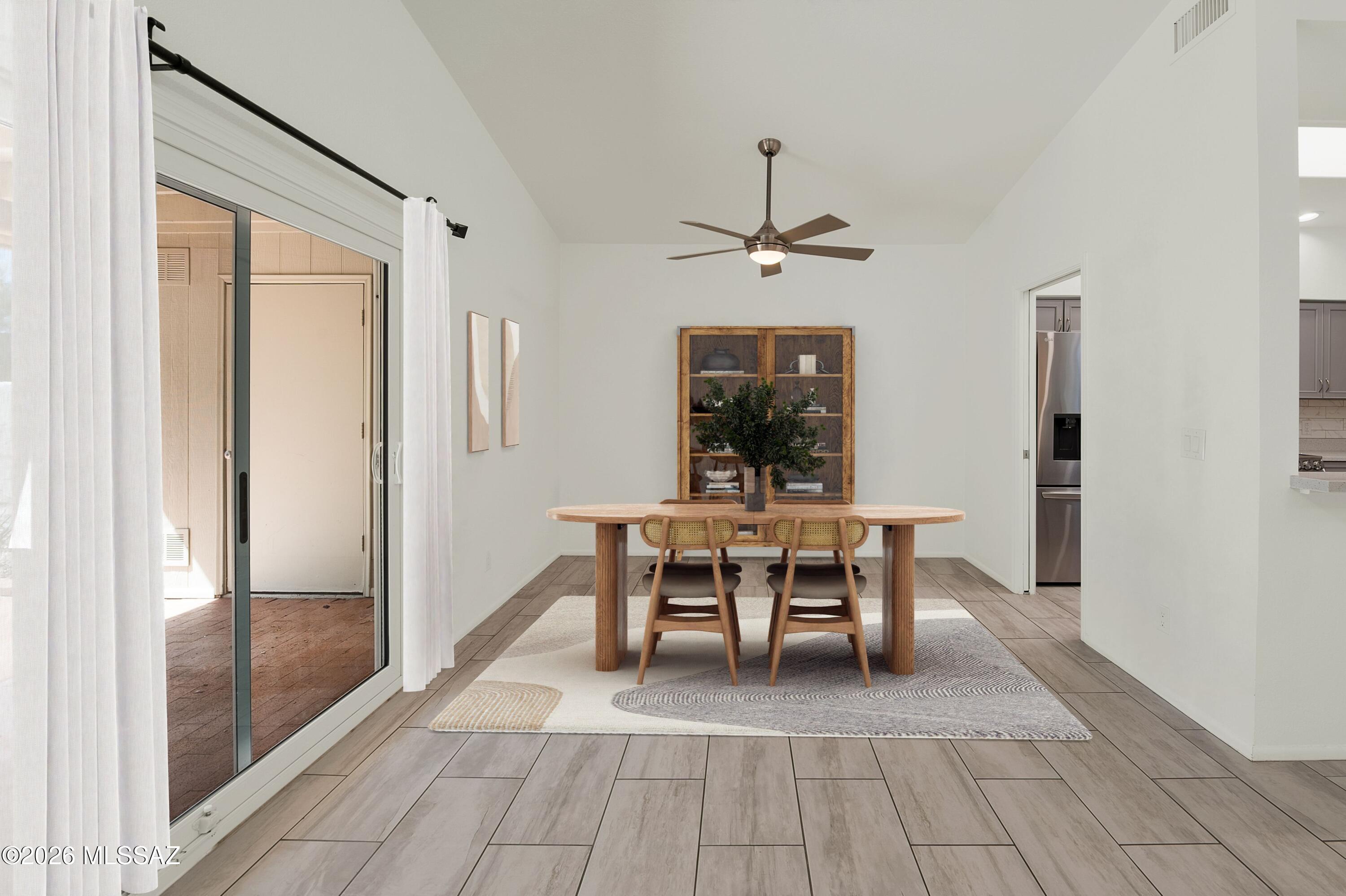 7408 East Wandering Road Tucson, AZ 85750 - Photo 9 of 25 a view of a dining room and livingroom with furniture wooden floor a chandelier