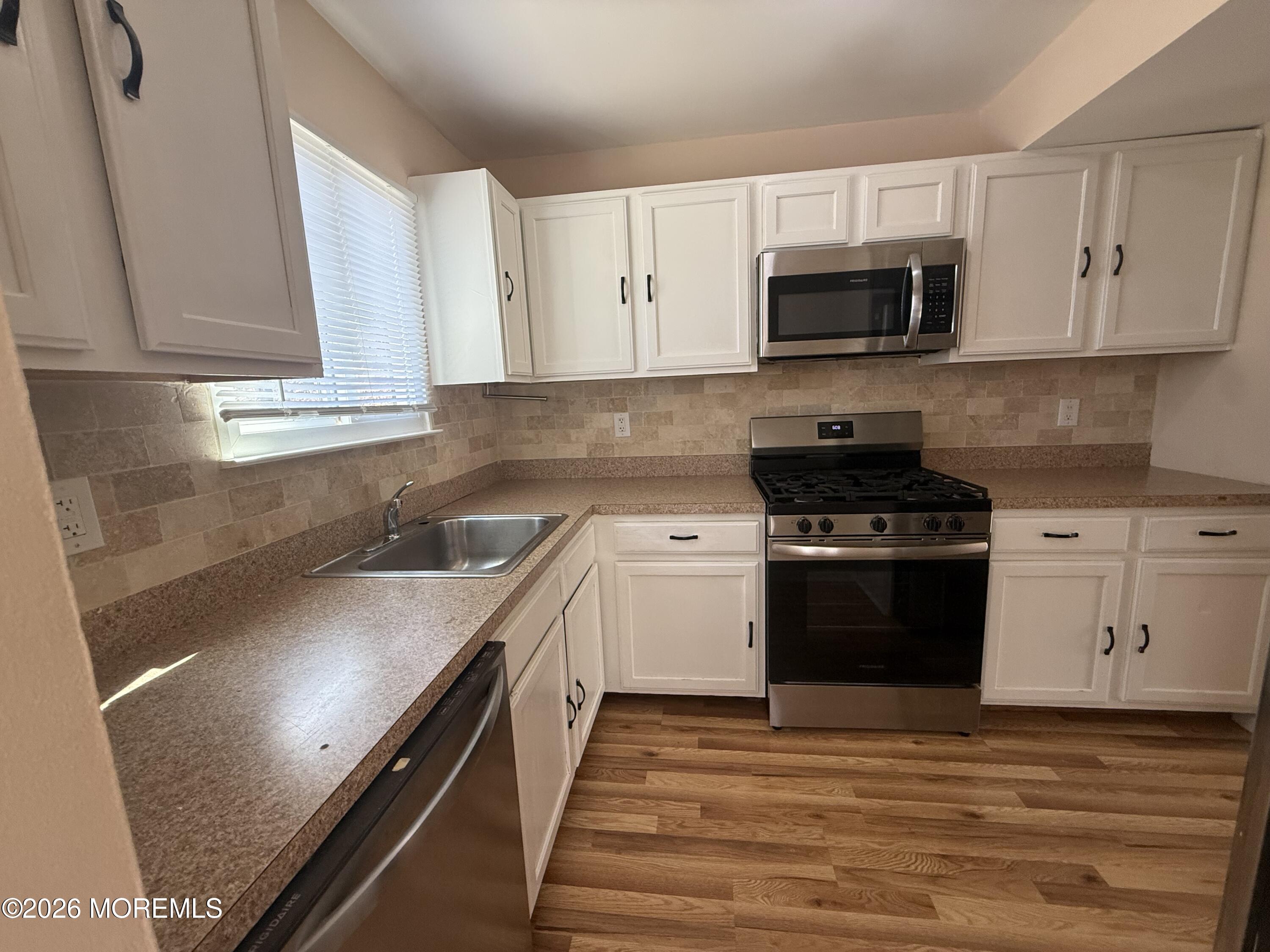 1 Max Place Howell, NJ 07731 - Photo 9 of 15 a kitchen with stainless steel appliances granite countertop a stove a sink and a microwave
