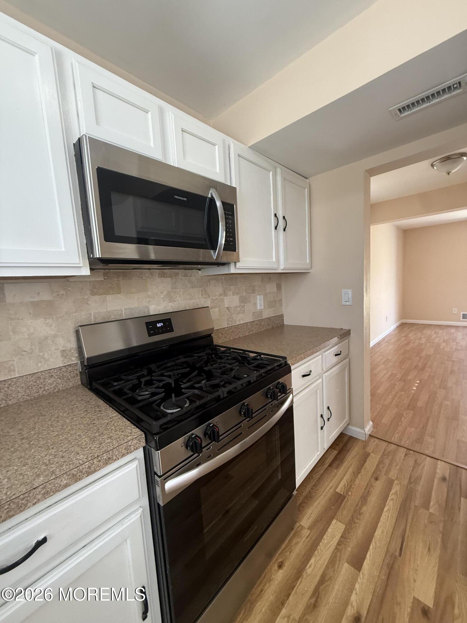 1 Max Place Howell, NJ 07731 - Photo 10 of 15 a kitchen with stainless steel appliances granite countertop a stove microwave and sink
