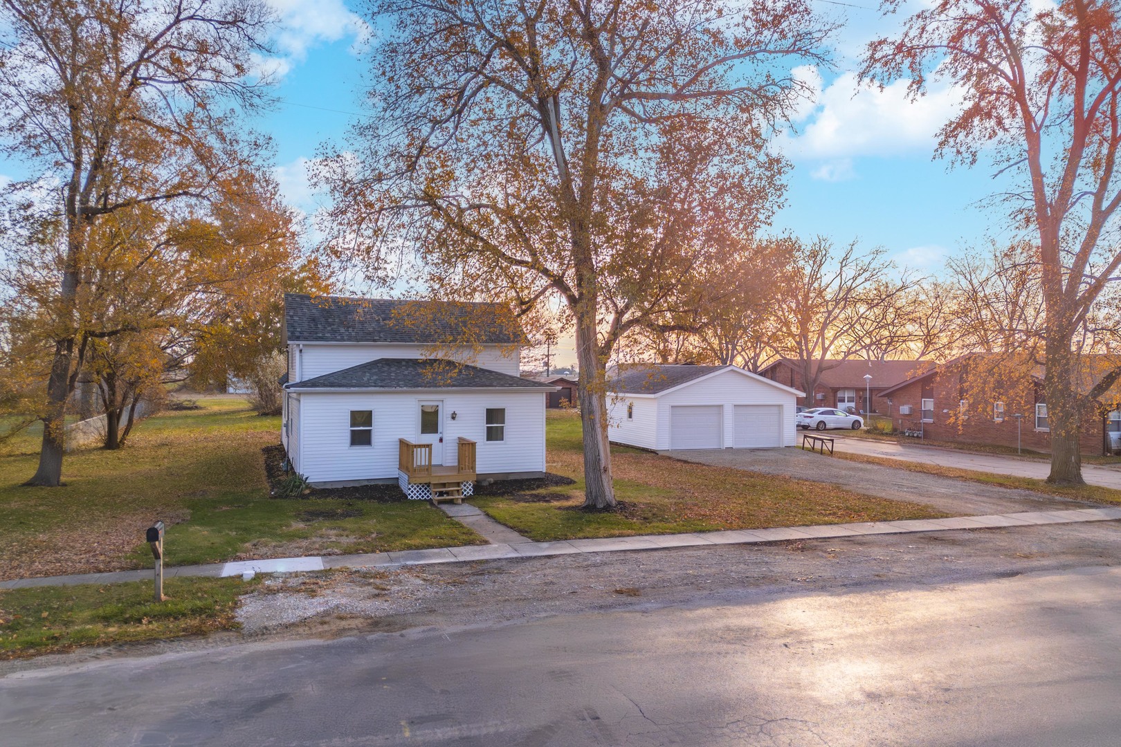 a front view of a house with a yard and large trees