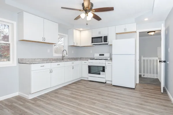 a kitchen with cabinets stainless steel appliances and wooden floor