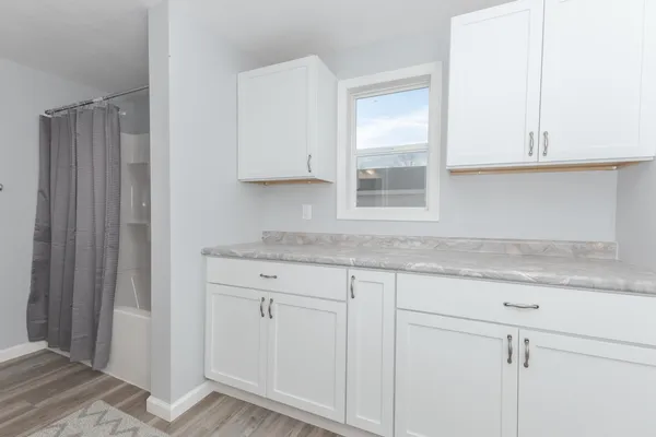 a kitchen with granite countertop white cabinets and a sink