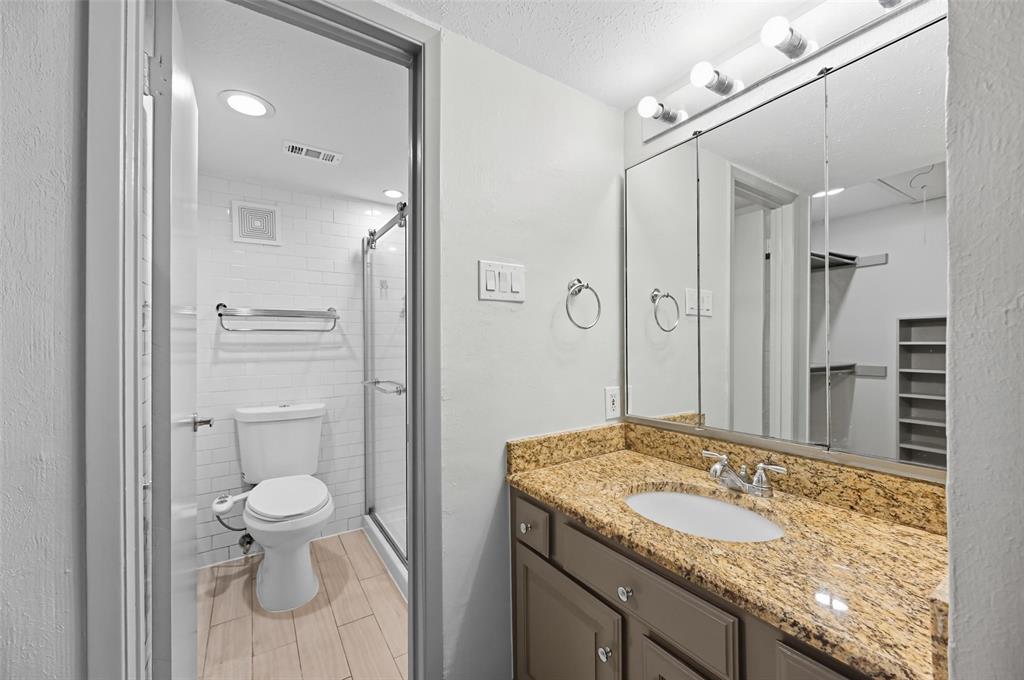 4521 North O'Connor Road, Unit 2169 Irving, TX 75062 - Photo 13 of 17 a bathroom with a granite countertop sink toilet and shower