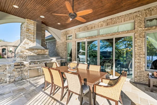 a spacious bedroom with a large bed a flat tv screen and a large window with the backyard view