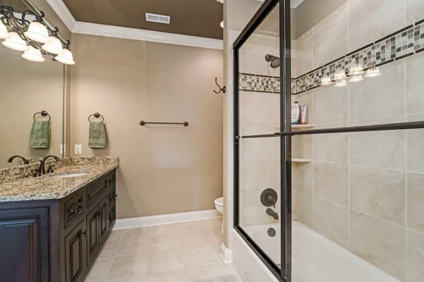 a bathroom with a granite countertop toilet a sink and a mirror