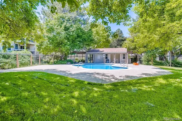 a view of house with swimming pool and yard
