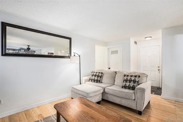 a living room with furniture and a wooden floor