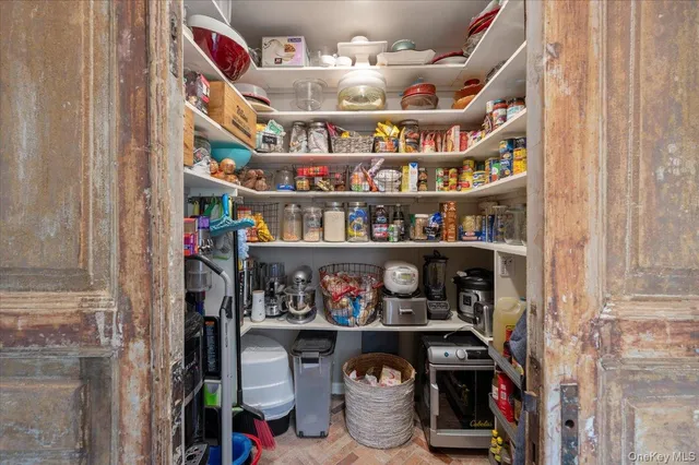 a view of a dining room and livingroom with furniture wooden floor a chandelier