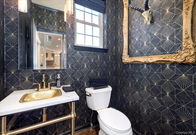 a bathroom with a sink a toilet and a window