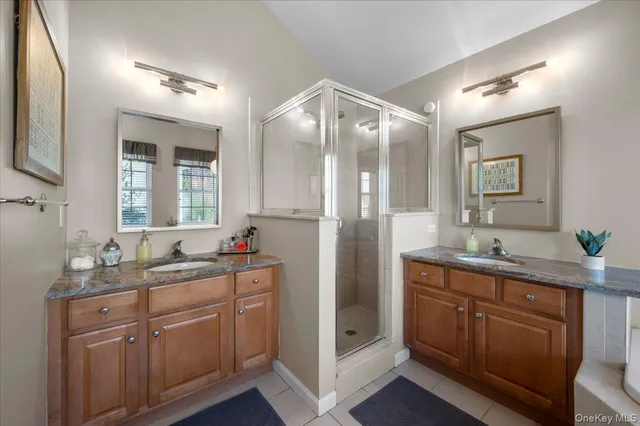 a en suite bathroom with a granite countertop sink a toilet and mirror