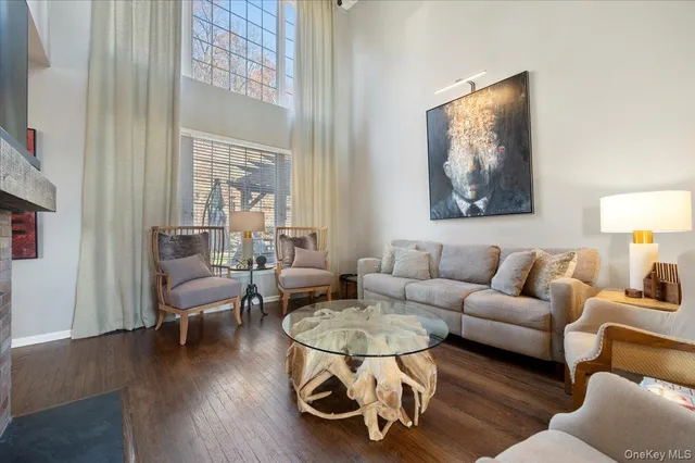 a living room with furniture a table and a painting next to a window