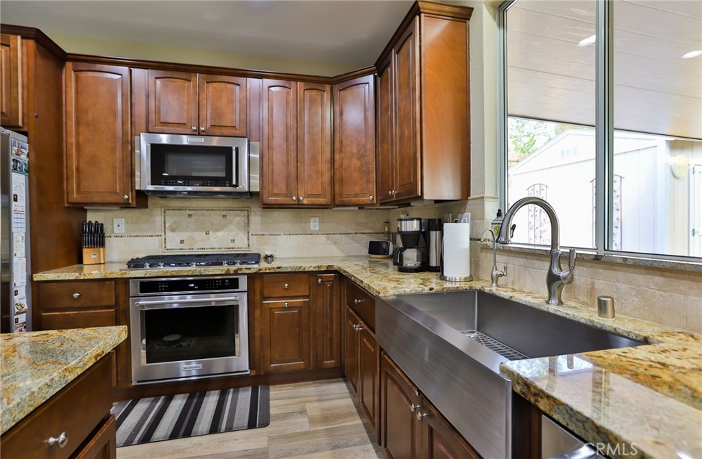 1789 Kapalua Bay Lane Corona, CA 92883 - Photo 22 of 63 a kitchen with a sink stove top oven and cabinets