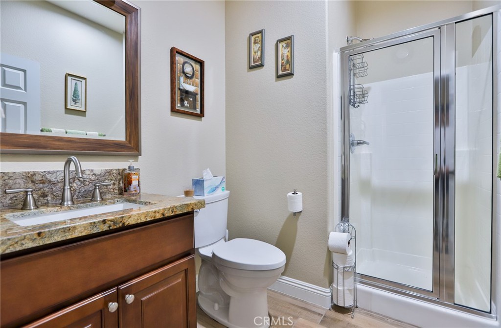 1789 Kapalua Bay Lane Corona, CA 92883 - Photo 28 of 63 a bathroom with a granite countertop sink toilet and shower