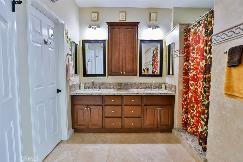 1789 Kapalua Bay Lane Corona, CA 92883 - Photo 32 of 63 a bathroom with a granite countertop sink and a mirror