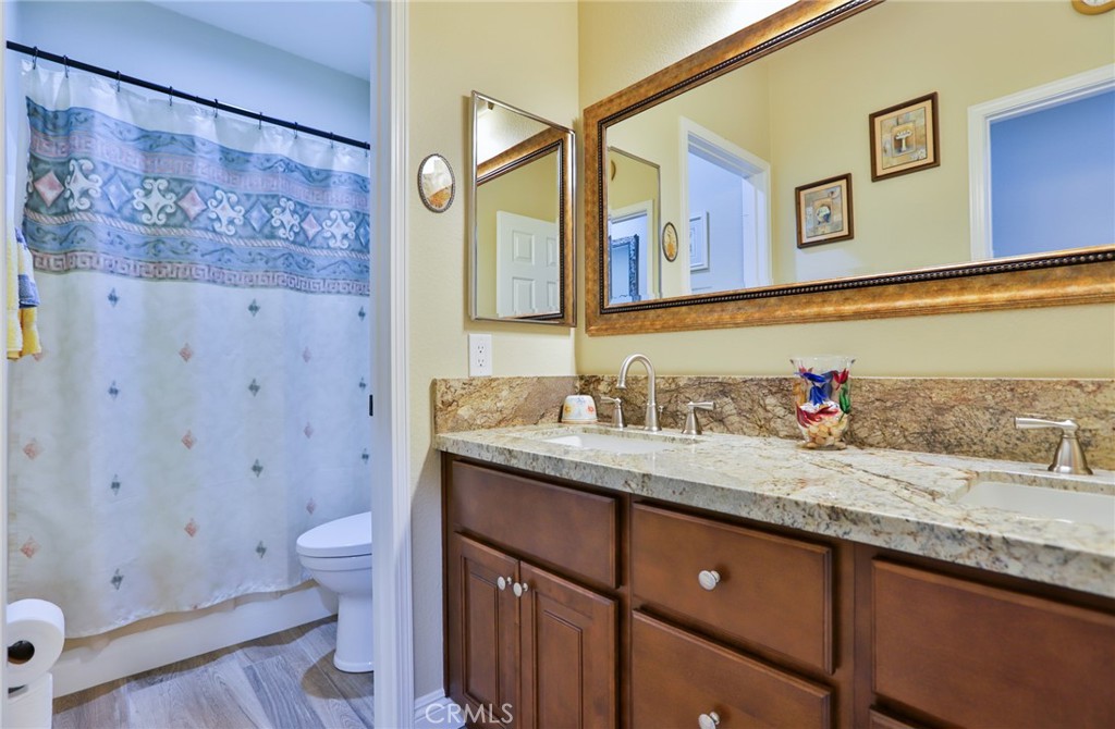 1789 Kapalua Bay Lane Corona, CA 92883 - Photo 41 of 63 a bathroom with a granite countertop sink mirror vanity and toilet