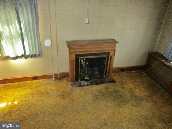 a view of an empty room with a fireplace and a window