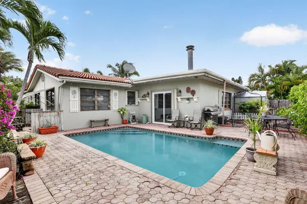 a view of a house with swimming pool and sitting area