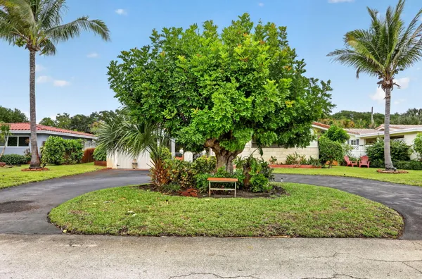 front view of a house with a yard and potted plants
