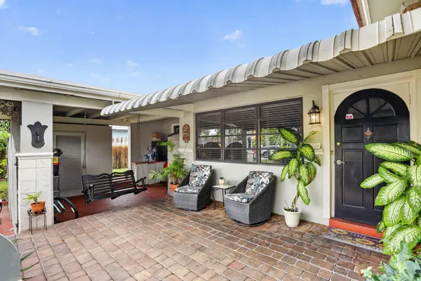 a front view of a house with outdoor seating and a potted plant