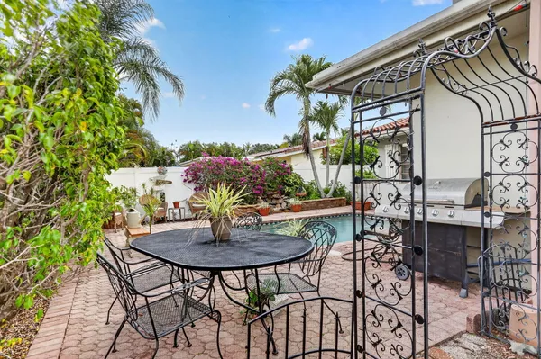 a patio with a table and chairs and potted plants