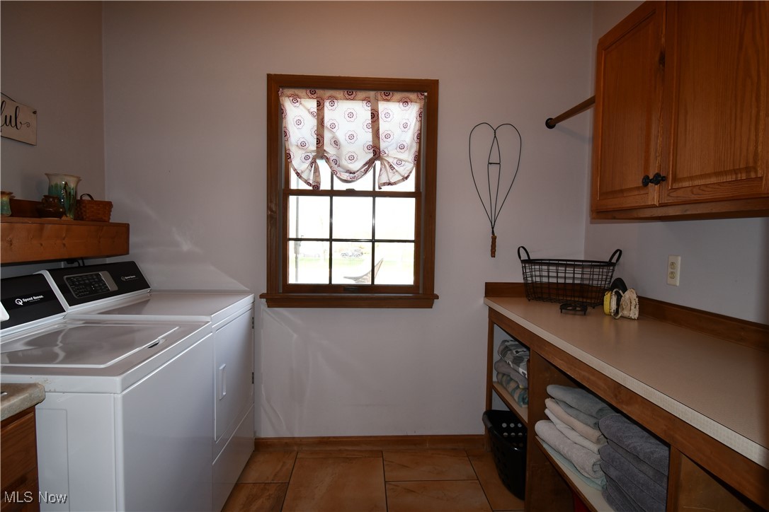 3180 West Calla Road Canfield, OH 44406 - Photo 28 of 49 Laundry room featuring light tile patterned flooring, washing machine and clothes dryer, and cabinet space