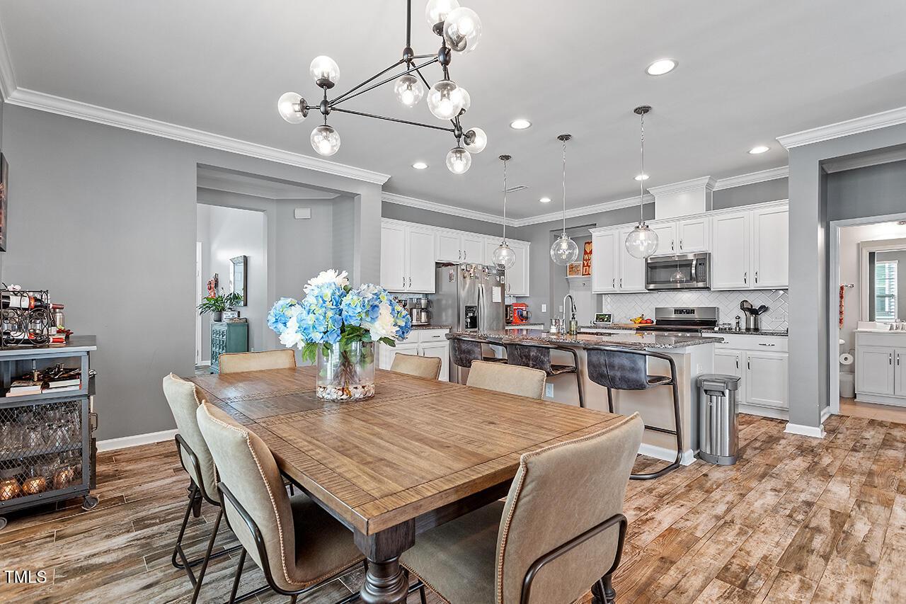 1420 Southpoint Trail Durham, NC 27713 - Photo 10 of 33 a kitchen with kitchen island a dining table chairs stainless steel appliances and cabinets