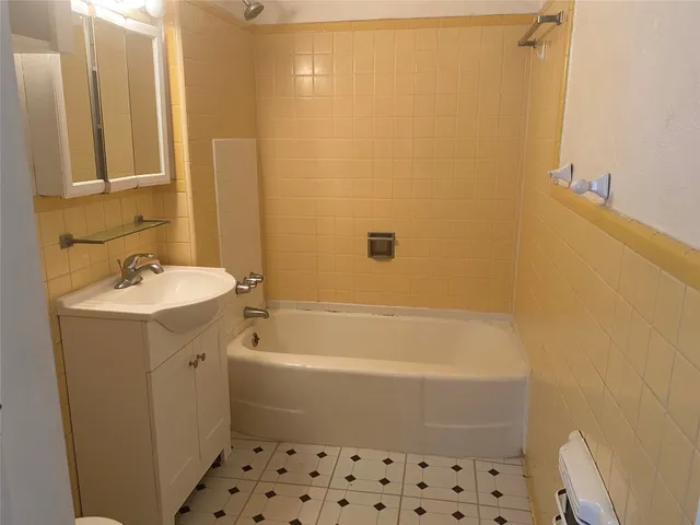 a bathroom with a bathtub a sink a toilet and a mirror