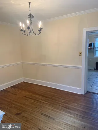 a view of a room with wooden floor and chandelier