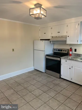 a kitchen with granite countertop white cabinets and white appliances