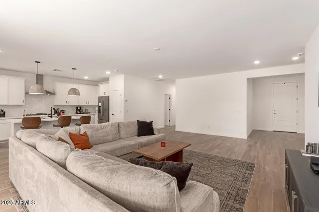 a living room with furniture and a view of kitchen