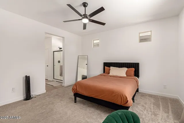 a bedroom with a bed and a ceiling fan