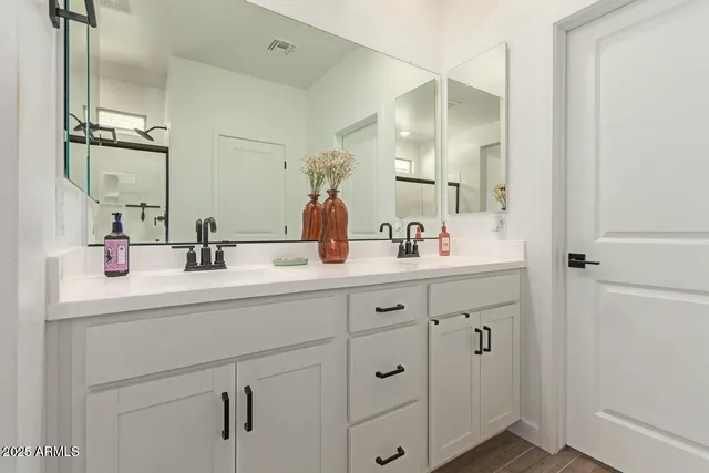 a bathroom with double sink and a mirror